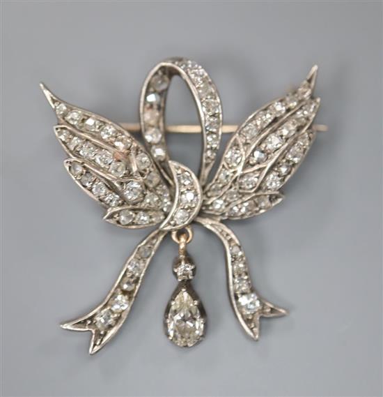 A Victorian yellow metal and old cut diamond set winged ribbon bow drop brooch, 28mm, gross 4.9 grams.
